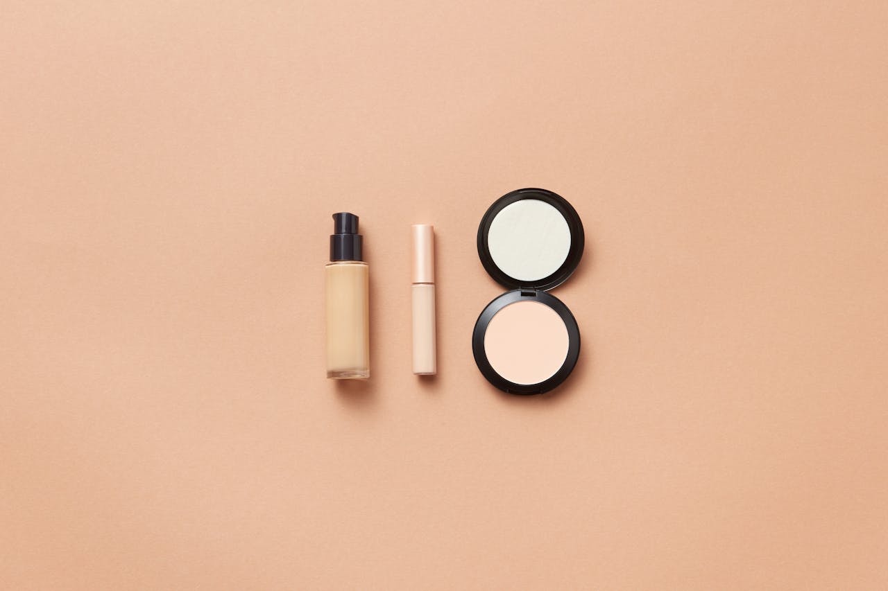 Services Flatlay of foundation, concealer, and compact powder on beige background. Perfect for beauty and cosmetic themes.